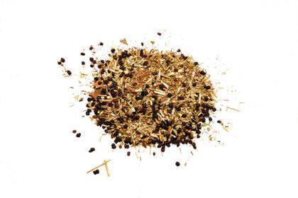 A pile of dried herbs and spices on top of a white surface.
