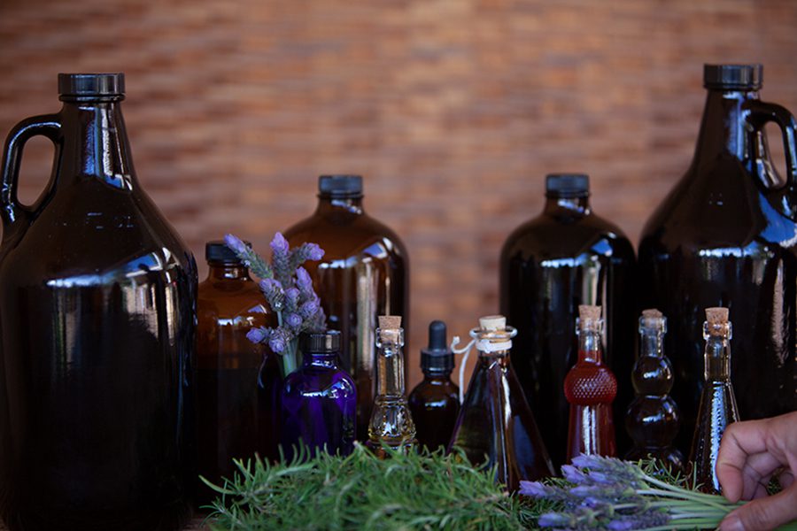 A table with several bottles of different oils and herbs.