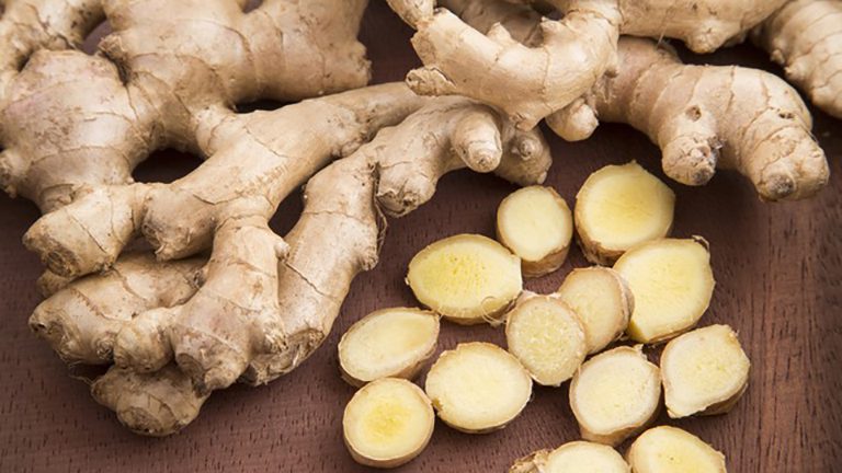 A close up of ginger root and sliced