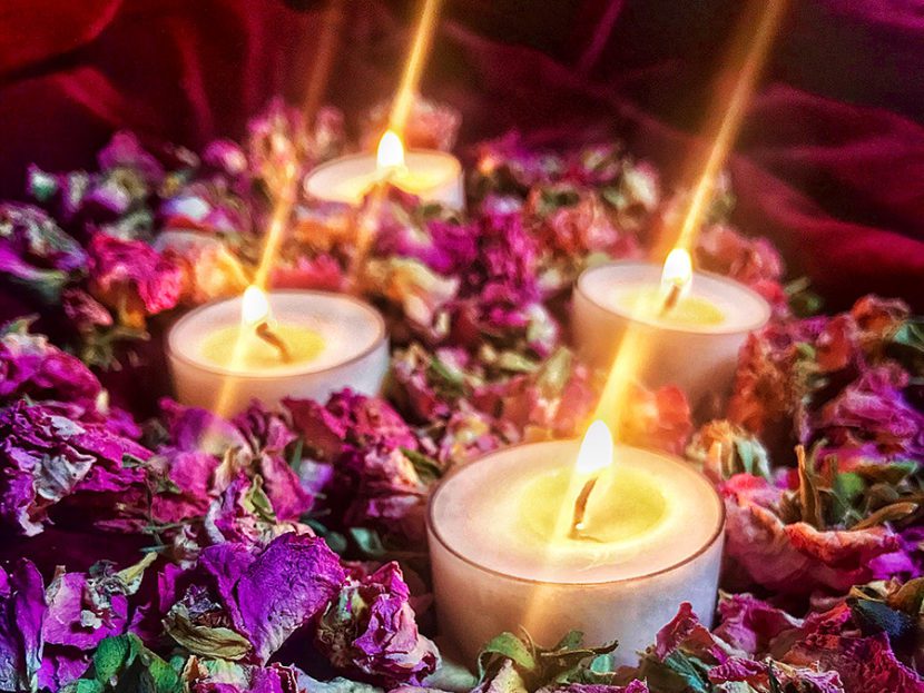 A group of candles sitting on top of flowers.