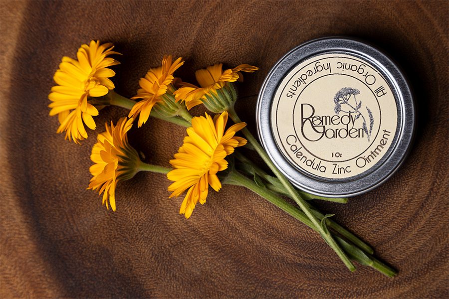 A wooden table with some yellow flowers and a candle