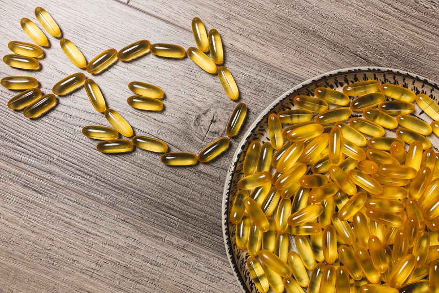 A bowl of fish oil and a necklace made out of beads.