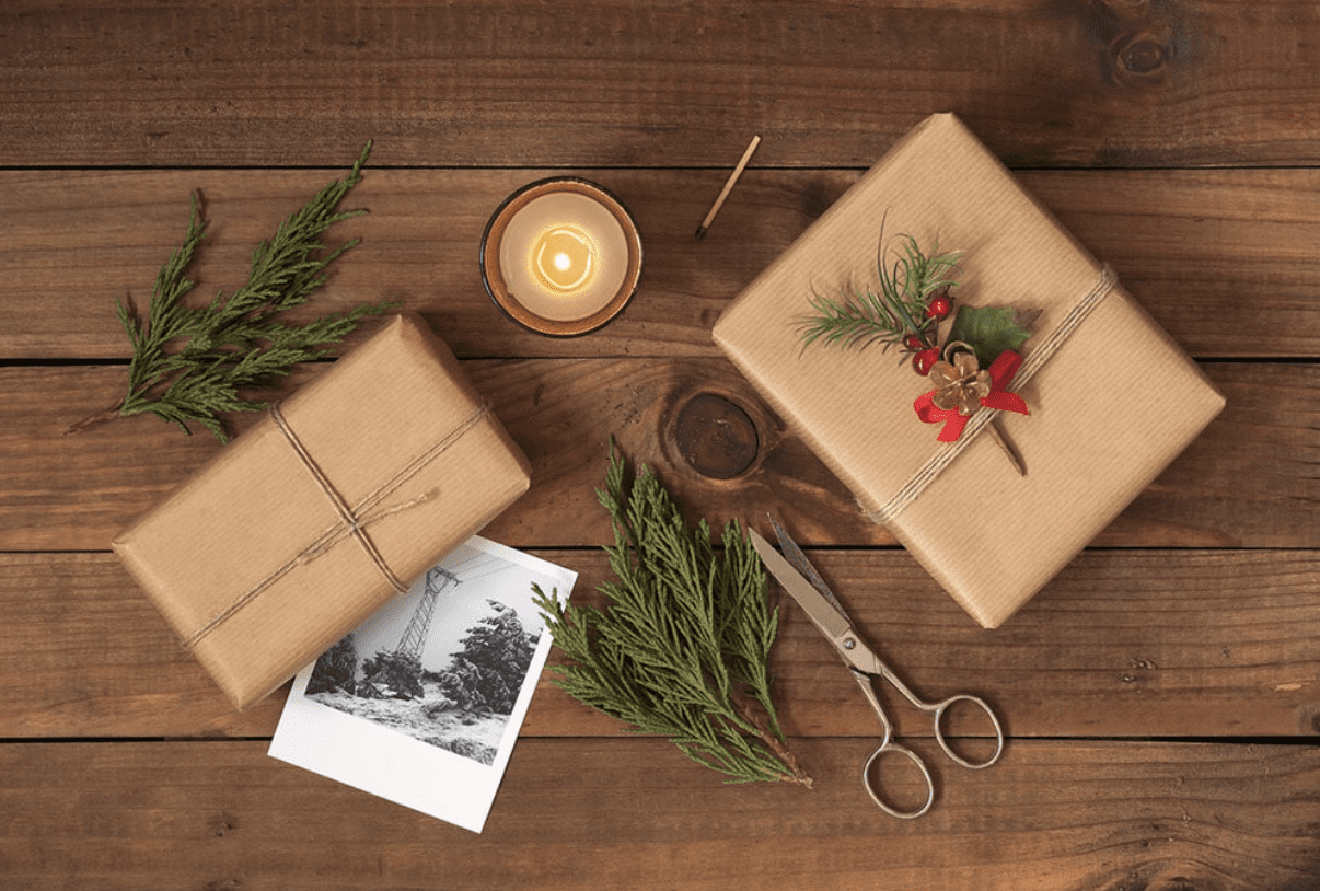 A wooden table topped with two packages of wrapping paper.