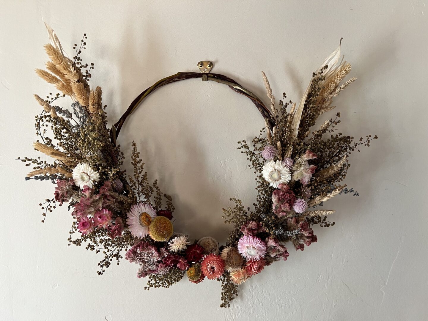 A wreath of dried flowers hanging on the wall.