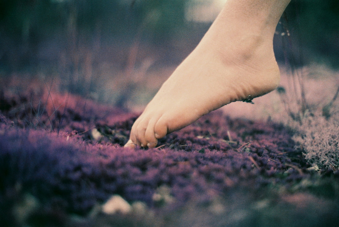 a barefoot lady stepping on the earth