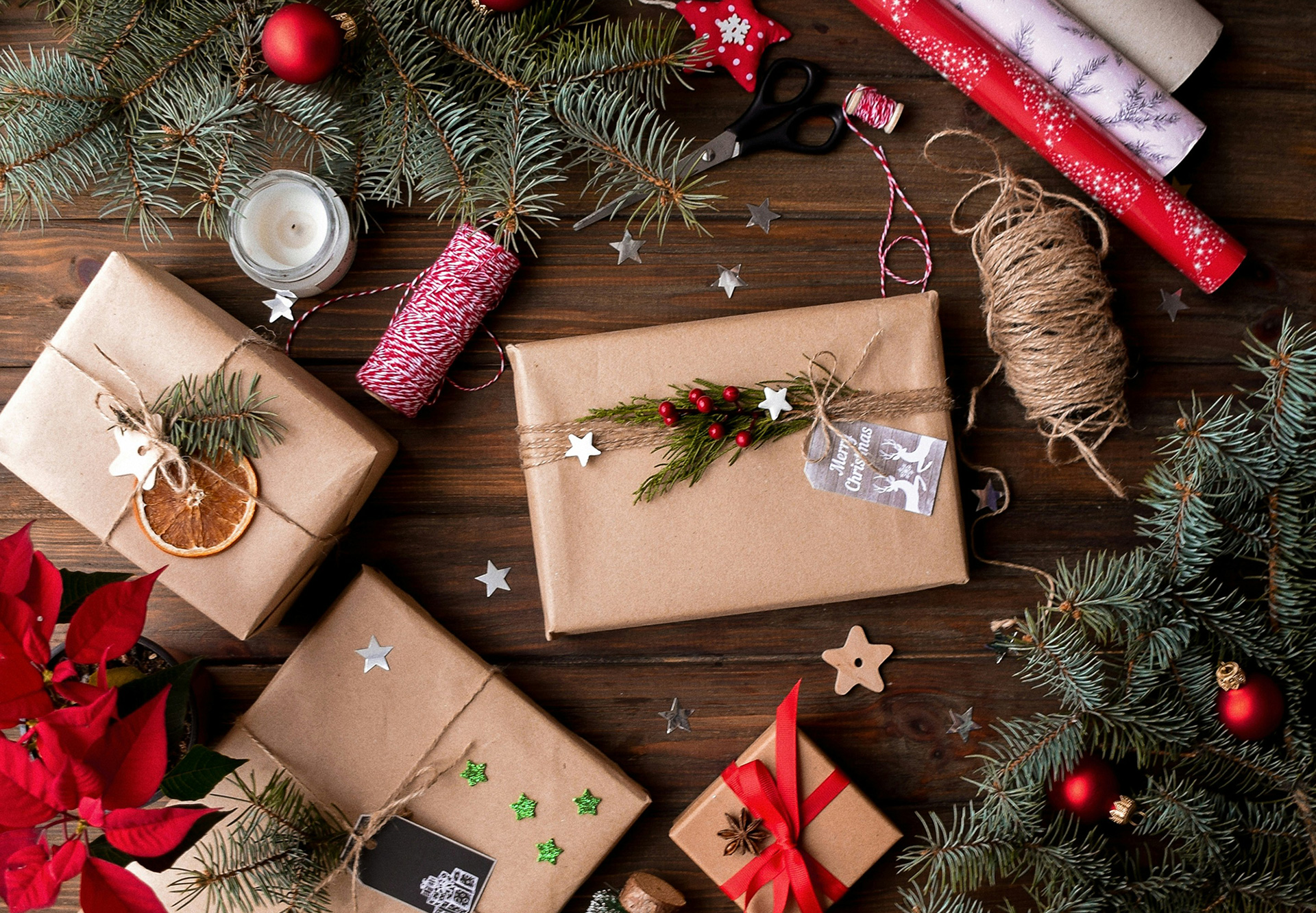 wrapped gifts with ribbon and scissors with christmas onaments and pine tree