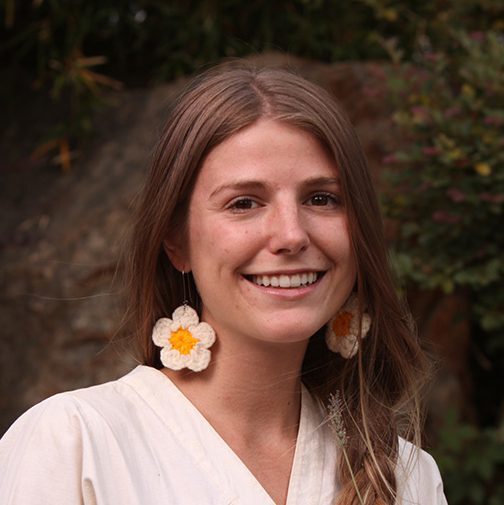 A woman with long hair wearing large earrings.